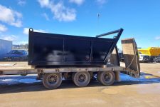 Black drainage bin loaded on a truck for transportation.
