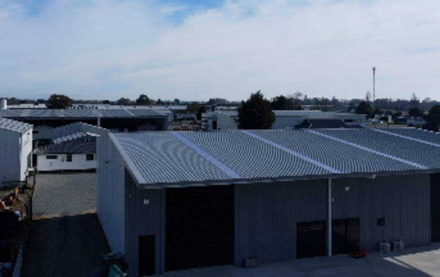 Industrial buildings with metal roofs under a clear sky.